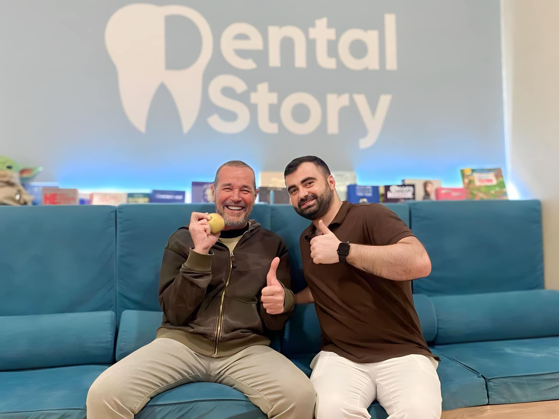 Two men in the Dental Story waiting area on a blue sofa